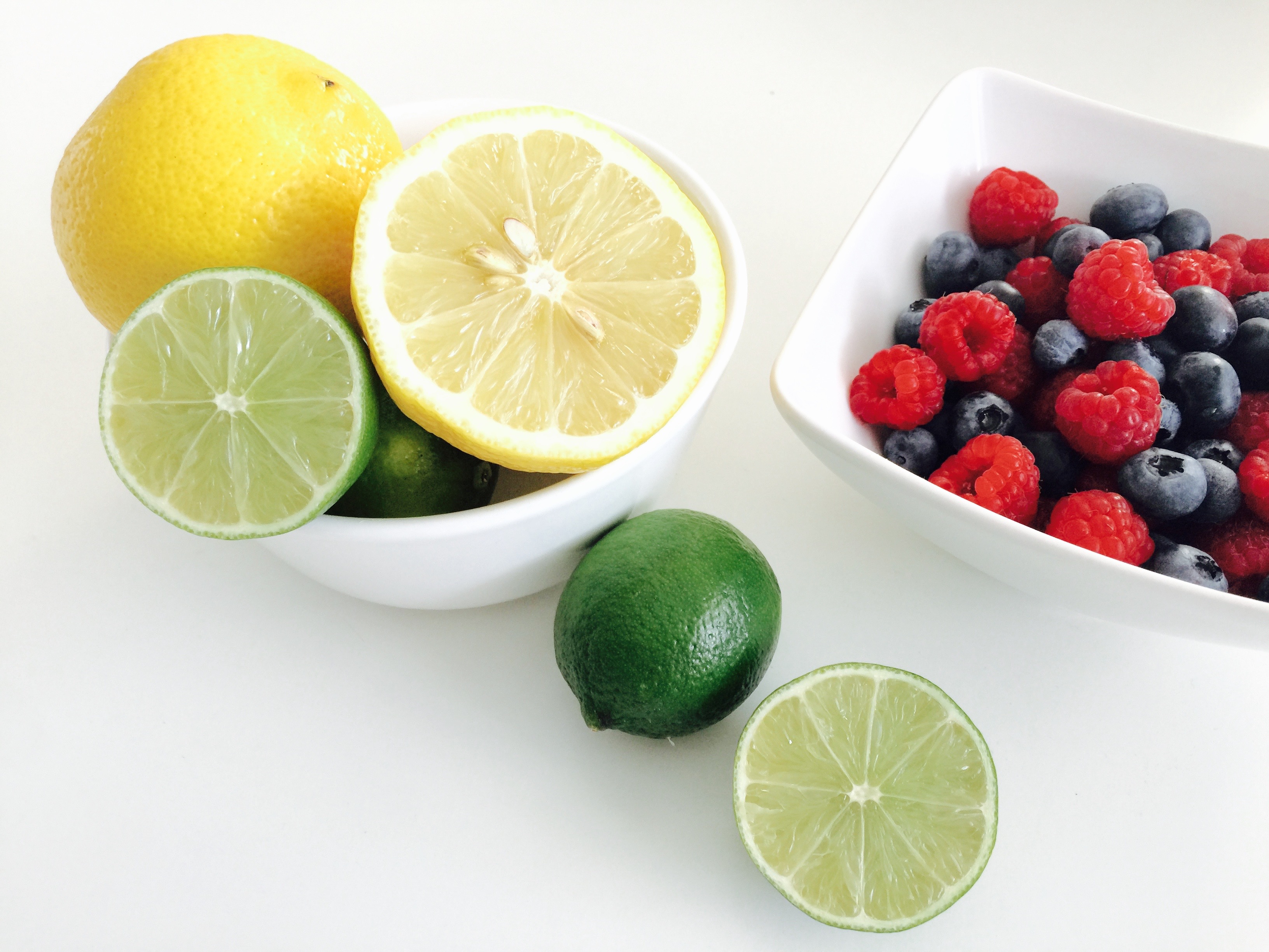 Čerstvé ovoce - Limeta a citrón a miska s borůvkami a malinami